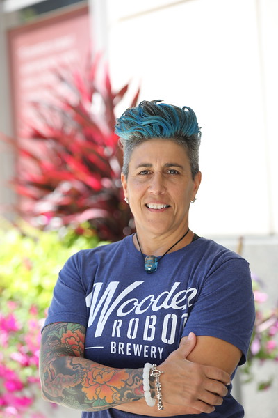 A woman with blue hair is smiling for the camera.